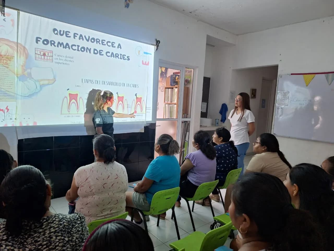 Una facilitadora expone un tema de salud bucal ante un grupo de mujeres.