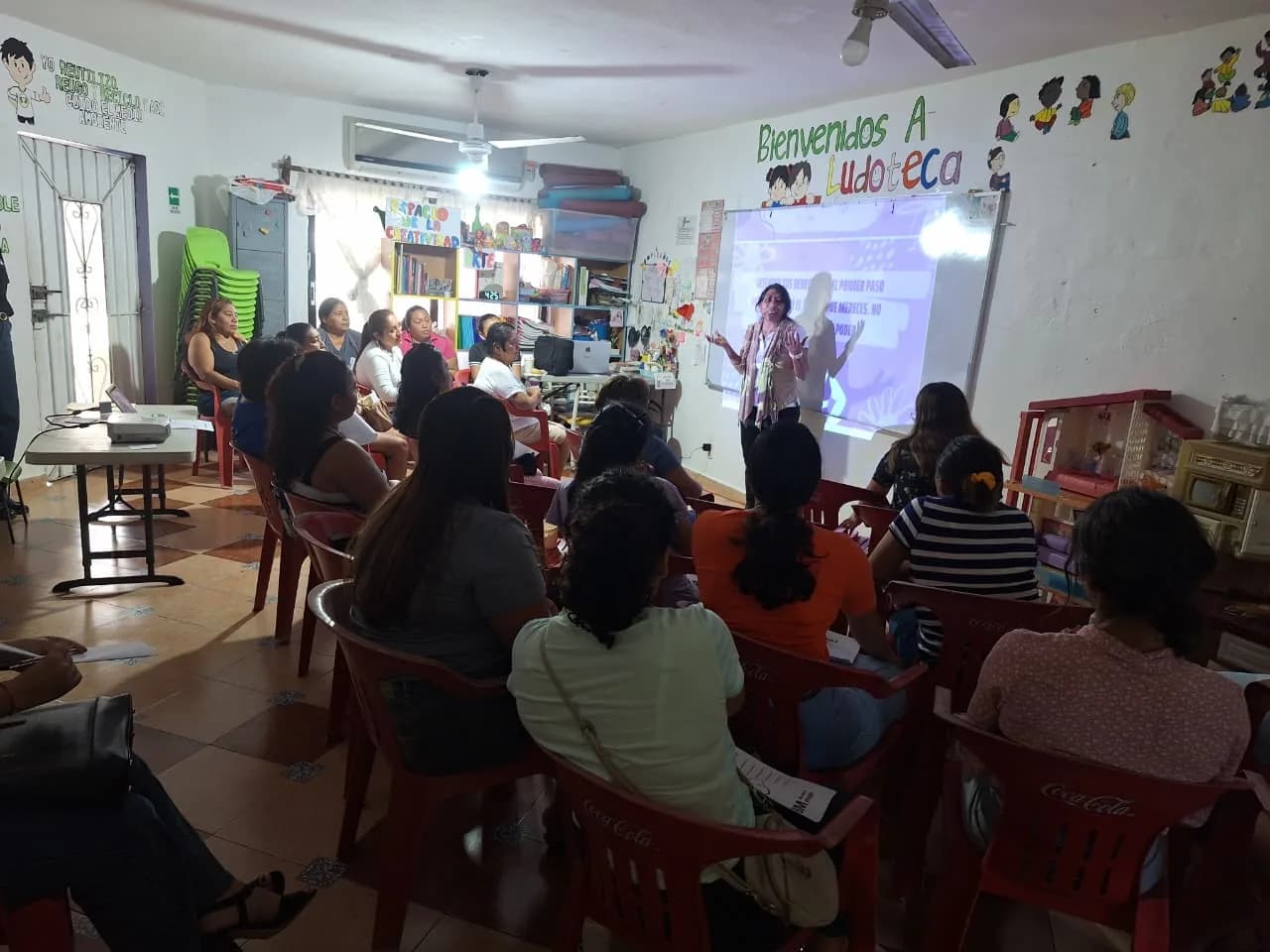 Una sesión del taller con la sala llena de mujeres siguiendo la presentación.