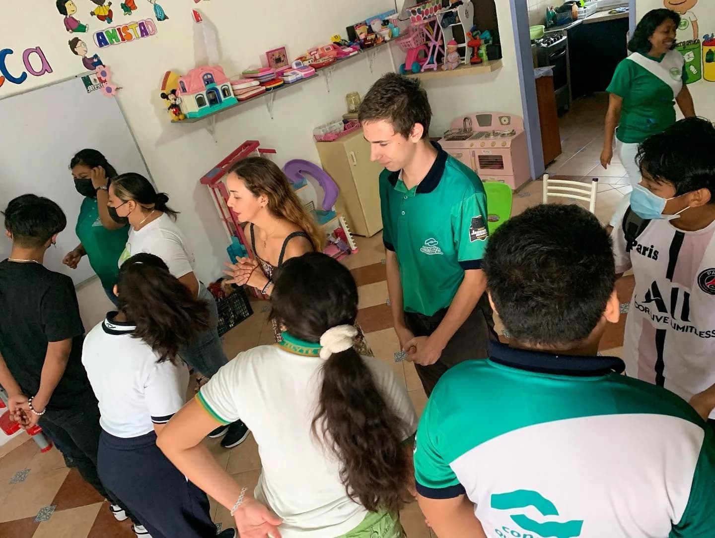 Un grupo de jóvenes recoge residuos con costales durante una jornada de limpieza de playa.